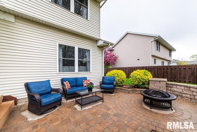 view of patio with fence and an outdoor living space with a fire pit