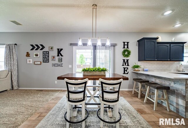 dining space with baseboards, recessed lighting, a textured ceiling, and visible vents