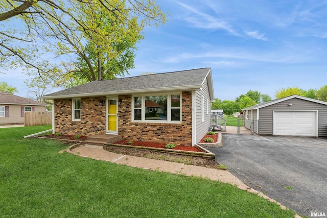 ranch-style house featuring aphalt driveway, a detached garage, brick siding, fence, and a front lawn