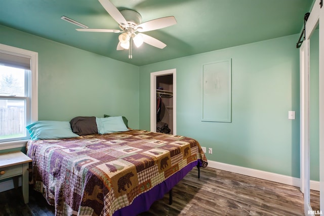 bedroom featuring ceiling fan, baseboards, wood finished floors, visible vents, and a closet