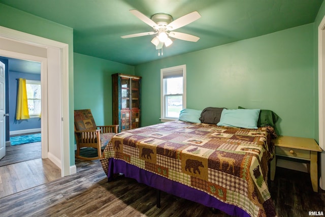 bedroom with baseboards, ceiling fan, and wood finished floors
