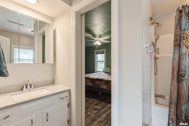 ensuite bathroom featuring vanity, shower / bath combination with curtain, wood finished floors, and a wealth of natural light