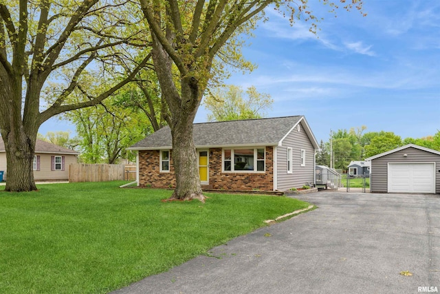 view of front facade featuring an outbuilding, a detached garage, brick siding, fence, and aphalt driveway