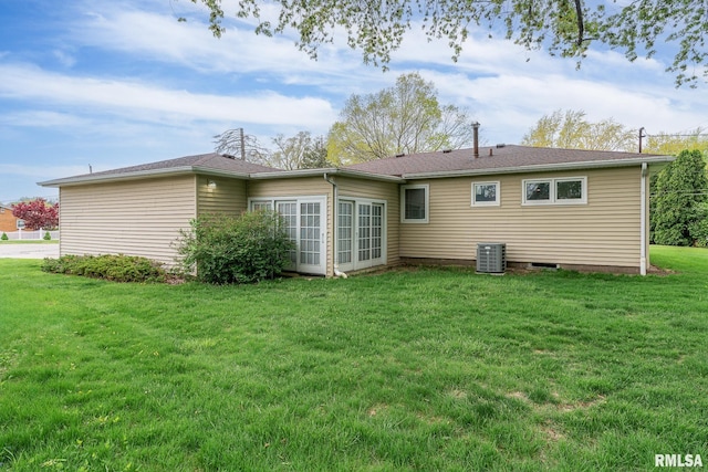 back of property with a lawn and central AC