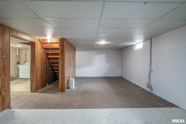 finished basement featuring stairs, washer / dryer, wood finished floors, and concrete block wall