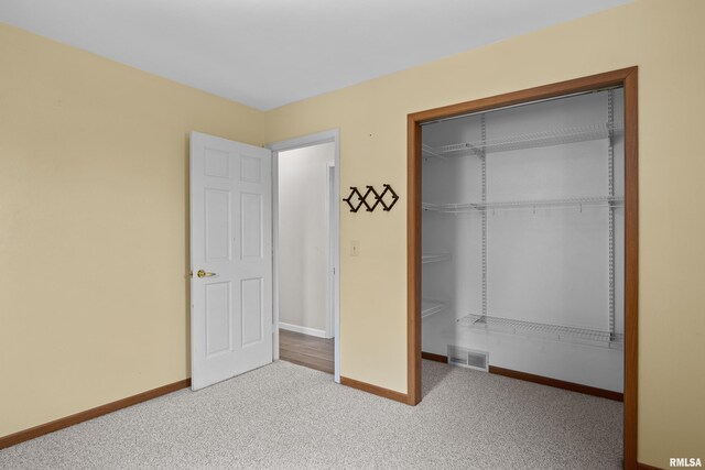 unfurnished bedroom featuring carpet flooring, baseboards, visible vents, and a closet