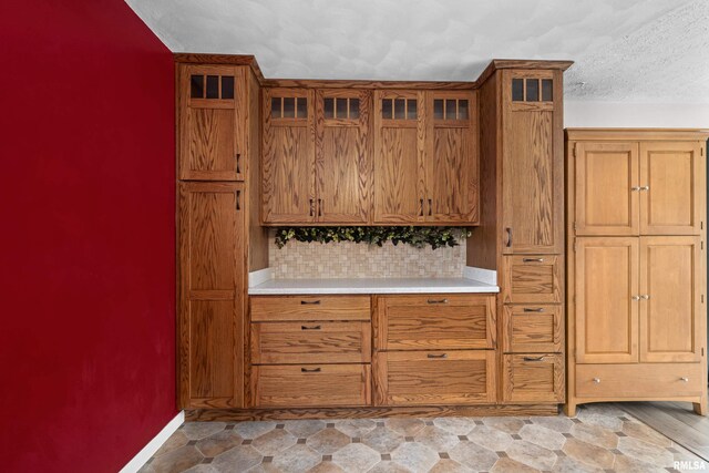 bar with baseboards, backsplash, and a textured ceiling