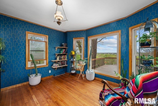 interior space featuring crown molding, plenty of natural light, hardwood / wood-style floors, and wallpapered walls