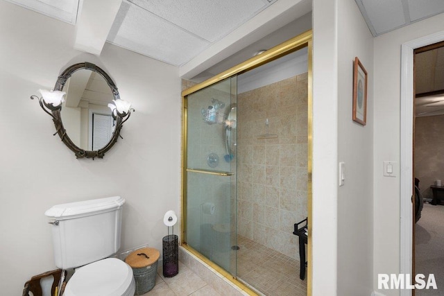 bathroom featuring toilet, a shower stall, and tile patterned flooring