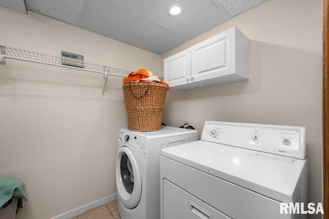 laundry room featuring light tile patterned floors, independent washer and dryer, and cabinet space