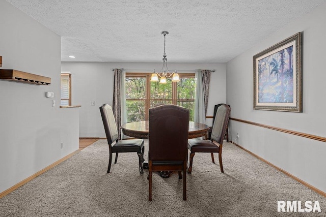 dining area with carpet floors, a textured ceiling, baseboards, and an inviting chandelier