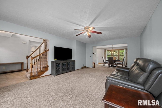 carpeted living room with baseboards, a textured ceiling, ceiling fan, and stairway