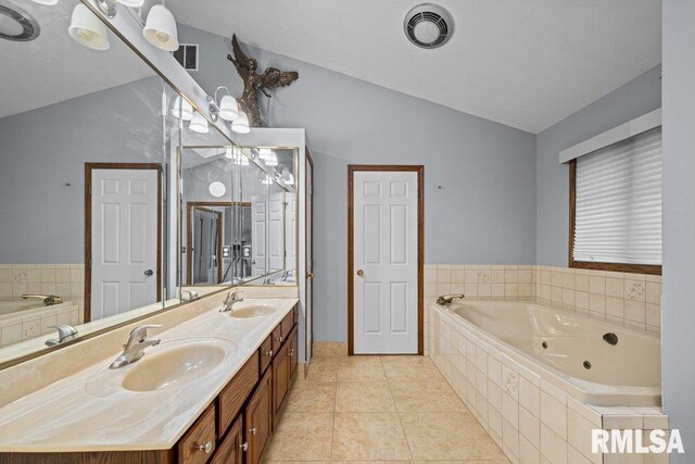 bathroom featuring vaulted ceiling, a tub with jets, a sink, and visible vents