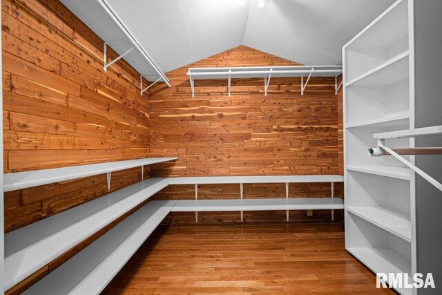 spacious closet with wood finished floors and vaulted ceiling