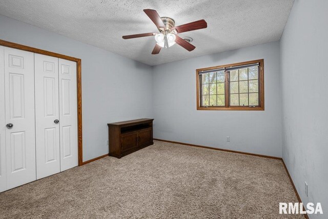 unfurnished bedroom featuring a closet, carpet flooring, a textured ceiling, and baseboards