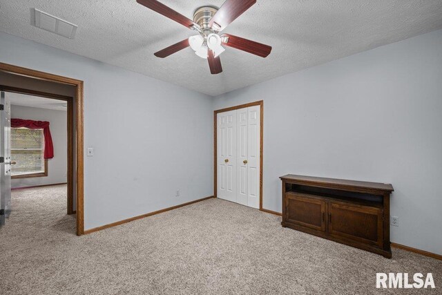 unfurnished bedroom with visible vents, a textured ceiling, and carpet floors