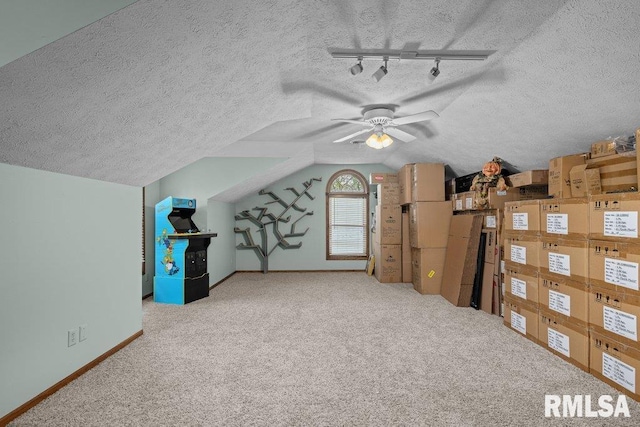 bonus room featuring lofted ceiling, baseboards, a textured ceiling, a ceiling fan, and carpet