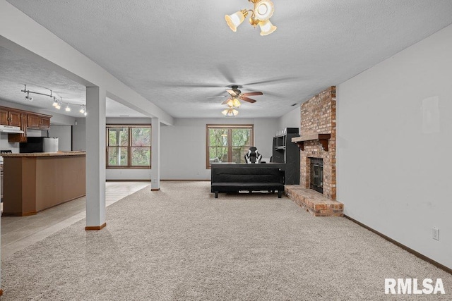 living room with ceiling fan, light carpet, and a textured ceiling