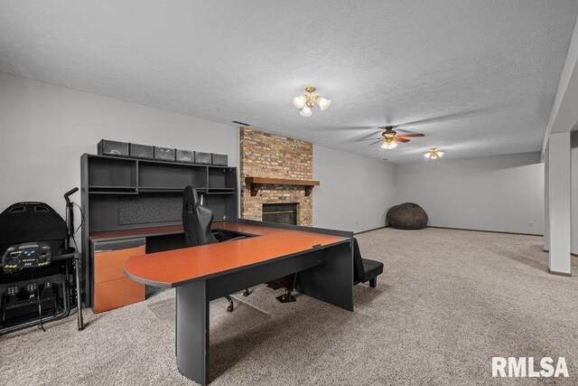home office featuring ceiling fan, a fireplace, a textured ceiling, and light colored carpet