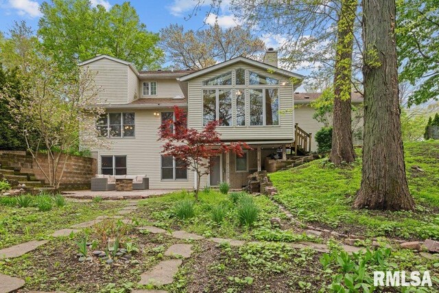 rear view of house with a patio, fence, a chimney, and an outdoor hangout area