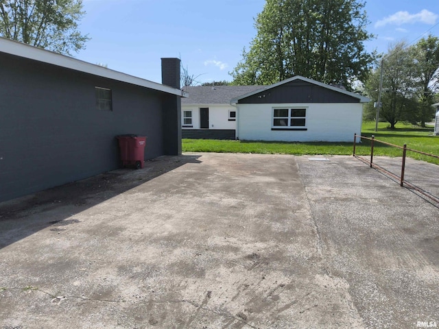 116 Ballantine St, Duquoin, IL 62832 - rear view of property featuring a chimney, a lawn, and a patio area
