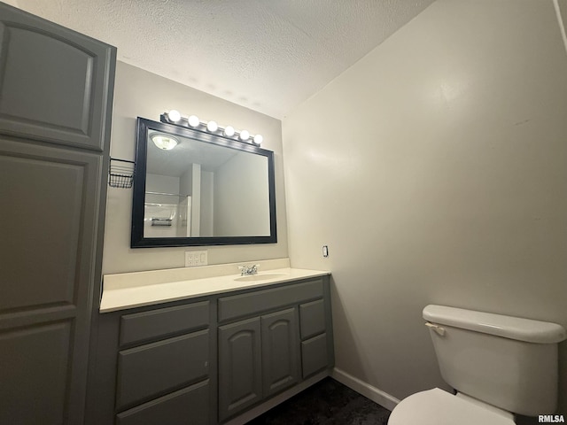 2000 W Gray Dr, Carbondale, IL 62901 - bathroom featuring vanity, toilet, baseboards, a textured ceiling, and vaulted ceiling