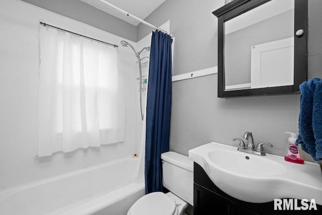 full bathroom featuring decorative backsplash, tile walls, vanity, toilet, and shower / bath combo with shower curtain