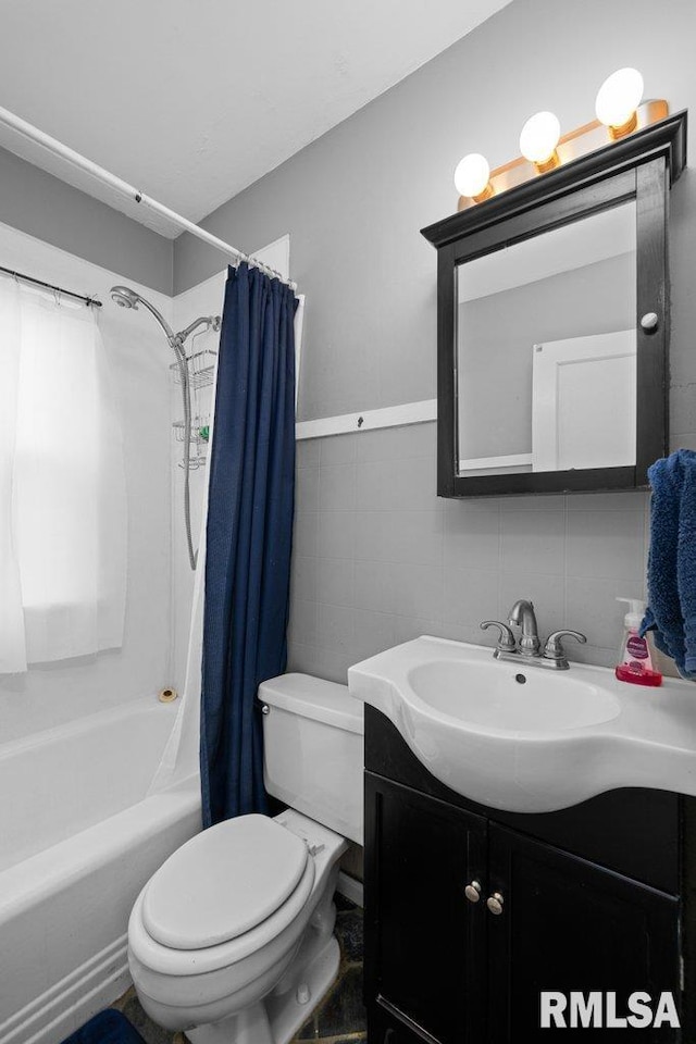 full bathroom featuring vanity, toilet, tile walls, and shower / bath combo with shower curtain