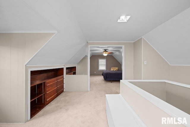 bonus room featuring wood walls, light colored carpet, and vaulted ceiling