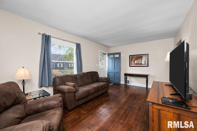 living area with baseboards, visible vents, and wood finished floors
