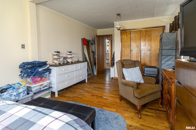 bedroom featuring a closet, ornamental molding, and hardwood / wood-style floors
