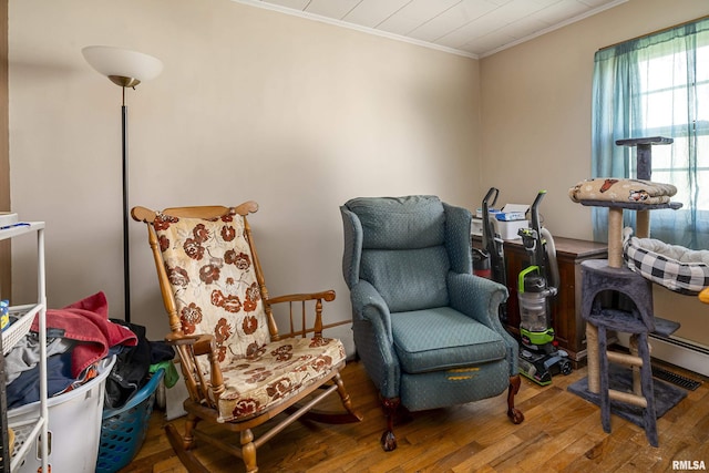 living area featuring crown molding and hardwood / wood-style flooring