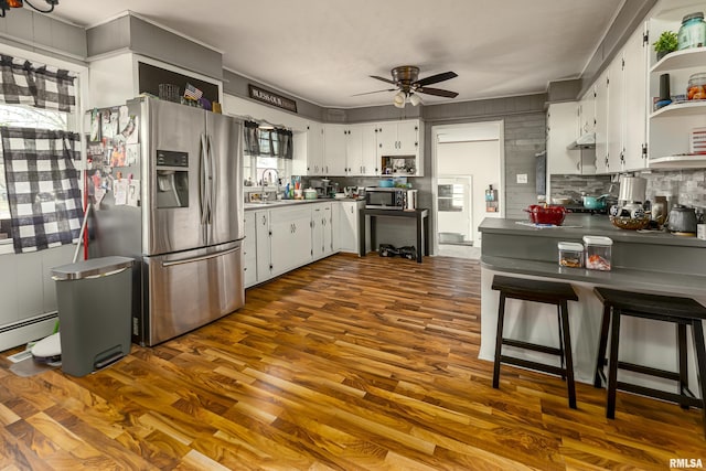 kitchen with open shelves, dark wood-type flooring, a ceiling fan, backsplash, and stainless steel appliances