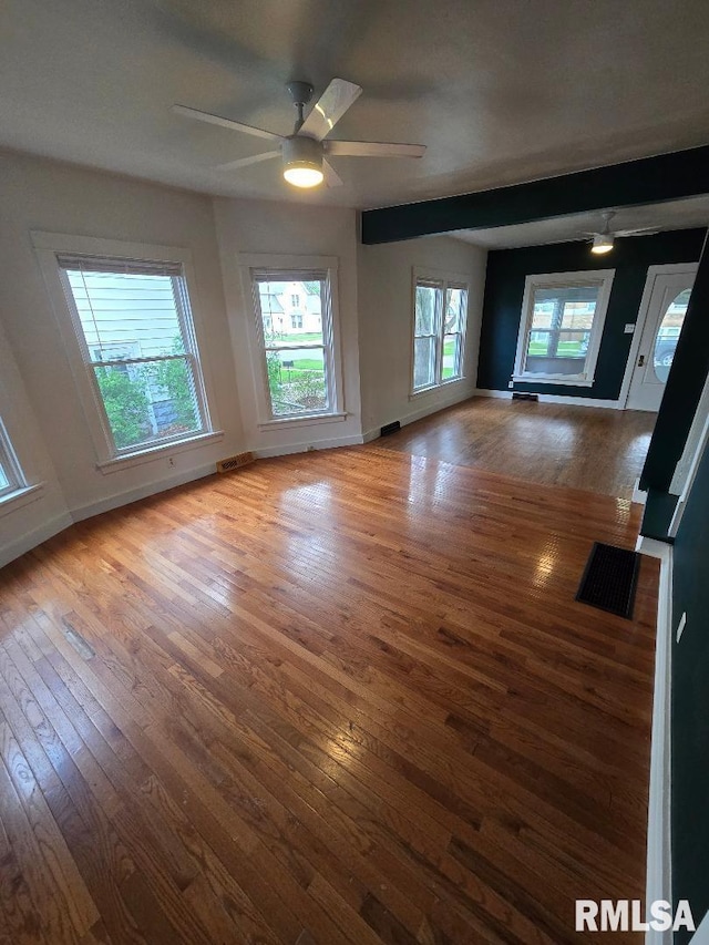spare room with visible vents, baseboards, ceiling fan, and hardwood / wood-style flooring
