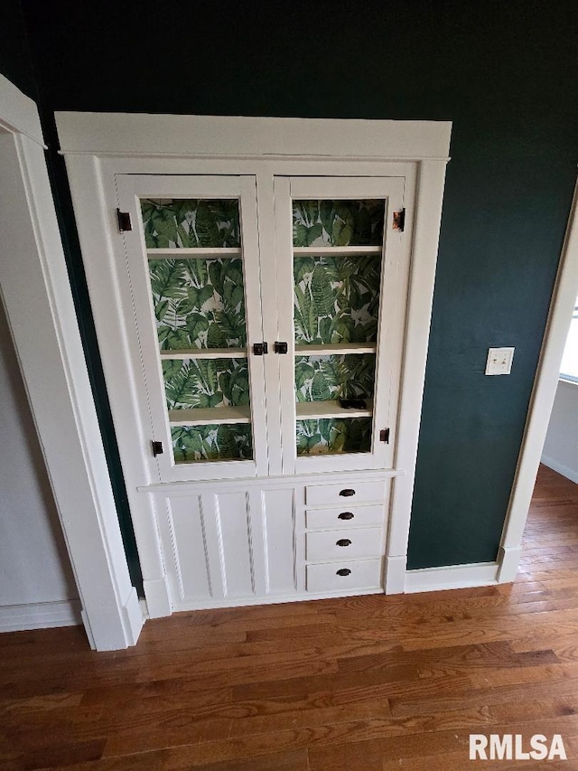 doorway with baseboards and wood finished floors