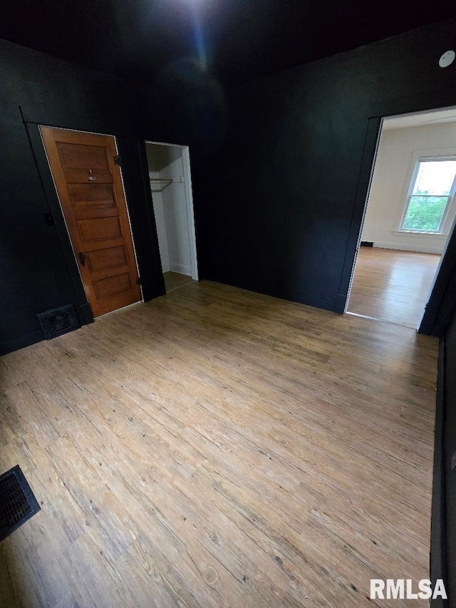 unfurnished room featuring wood finished floors and visible vents
