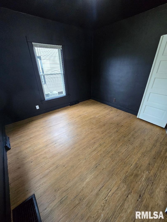unfurnished room with wood finished floors