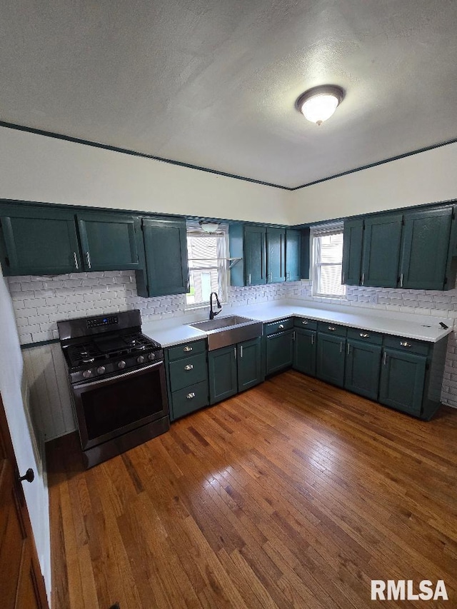 kitchen featuring a sink, a wealth of natural light, backsplash, and gas range oven