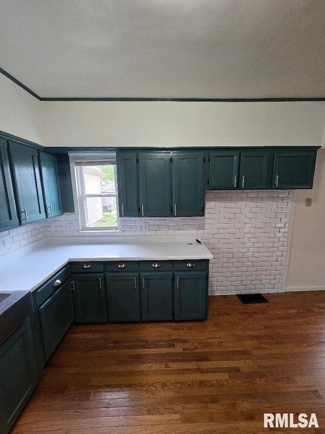 kitchen with light countertops, dark wood finished floors, and decorative backsplash