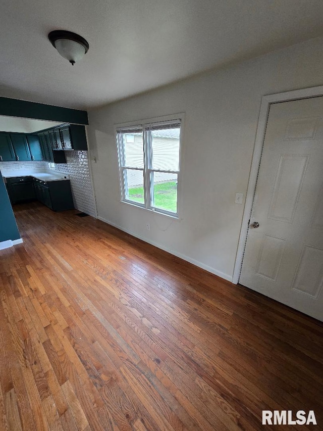 unfurnished living room with baseboards and wood finished floors