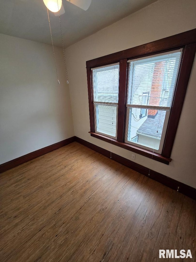 spare room featuring baseboards, a ceiling fan, and wood finished floors