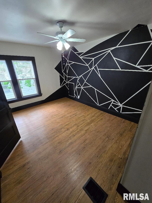 interior space featuring visible vents, a ceiling fan, and wood finished floors