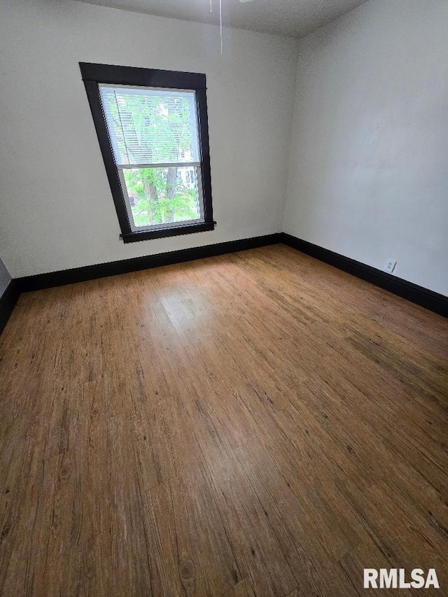unfurnished room featuring baseboards and wood finished floors