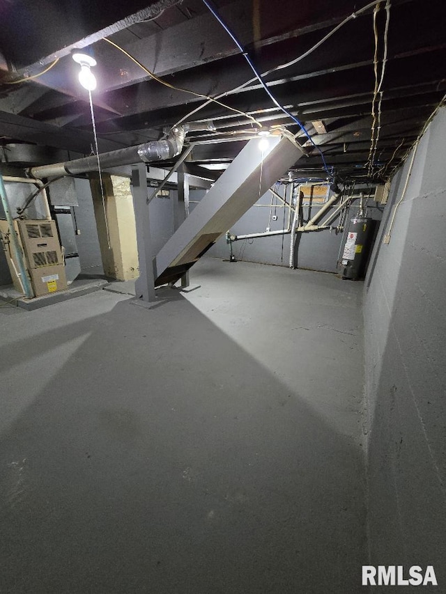 unfinished basement featuring heating unit and water heater