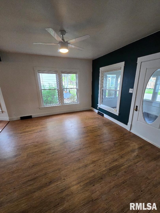 entrance foyer with baseboards, ceiling fan, wood finished floors, and a wealth of natural light