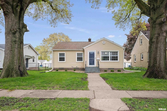 bungalow featuring entry steps, a chimney, a front lawn, and crawl space