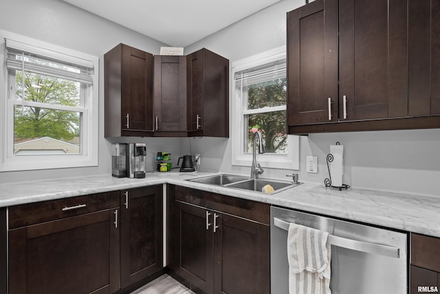kitchen with a sink, plenty of natural light, stainless steel dishwasher, and dark brown cabinets