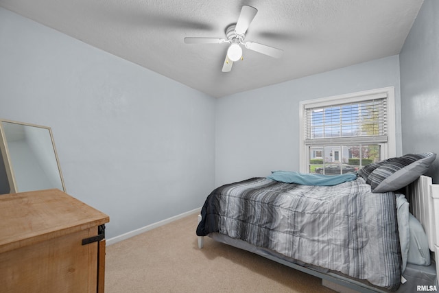 bedroom featuring carpet flooring, a ceiling fan, baseboards, and a textured ceiling