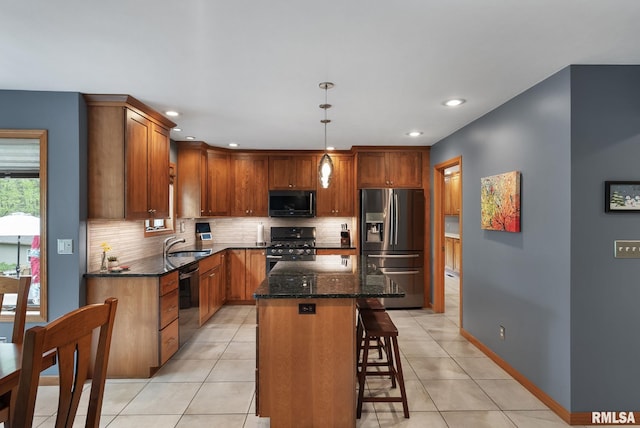 kitchen featuring appliances with stainless steel finishes, a kitchen bar, light tile patterned floors, and tasteful backsplash