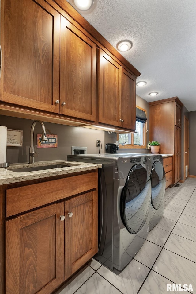 laundry room featuring marble finish floor, a textured ceiling, a sink, cabinet space, and independent washer and dryer